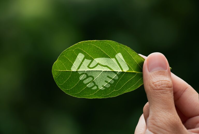 Hand,of,human,is,holding,painted,green,leaf,with,handshake